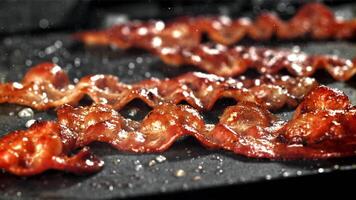 bacon é frito dentro uma frigideira. filmado em uma alta velocidade Câmera às 1000 fps. Alto qualidade fullhd cenas video