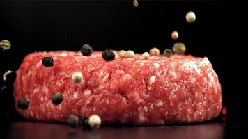 Peppercorn falls on a raw meat burger. Filmed on a high-speed camera at 1000 fps. High quality FullHD footage video