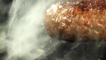 une du boeuf Burger chutes dans une chaud la poêle avec une éclaboussure de huile. filmé sur une haute vitesse caméra à 1000 ips. haute qualité Full HD métrage video