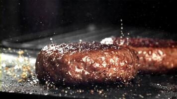 un carne de vaca hamburguesa caídas dentro un caliente pan con un chapoteo de aceite. filmado en un alta velocidad cámara a 1000 fps. alto calidad full HD imágenes video