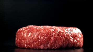 een vers vlees hamburger valt Aan een zwart tafel. gefilmd Aan een hoge snelheid camera Bij 1000 fps. hoog kwaliteit full HD beeldmateriaal video