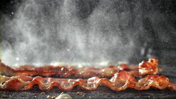 il Bacon è fritte nel un' padella con un' spruzzo di olio. girato su un' alta velocità telecamera a 1000 fps. alto qualità FullHD metraggio video