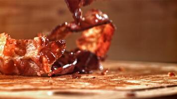 Roasted slices of bacon fall on a wooden table. Filmed on a high-speed camera at 1000 fps. High quality FullHD footage video