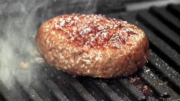 un' Manzo hamburger cascate in un' caldo padella con un' spruzzo di olio. girato su un' alta velocità telecamera a 1000 fps. alto qualità FullHD metraggio video