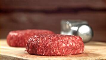 A fresh beef burger falls onto a cutting board. Filmed on a high-speed camera at 1000 fps. High quality FullHD footage video