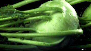 Kohlrabi falls on the table with a splash of water. Filmed on a high-speed camera at 1000 fps. High quality FullHD footage video