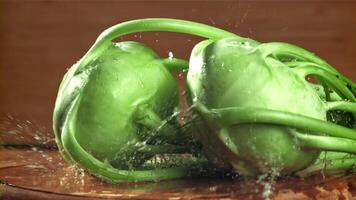 Kohlrabi Stürze auf das Tabelle mit ein Spritzen von Wasser. gefilmt auf ein schnelle Geschwindigkeit Kamera beim 1000 fps. hoch Qualität fullhd Aufnahmen video