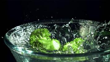 brócoli caídas dentro un cuenco de agua. filmado en un alta velocidad cámara a 1000 fps. alto calidad full HD imágenes video