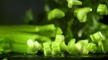 Pieces of chopped celery fall on the table. Filmed on a high-speed camera at 1000 fps. High quality FullHD footage video