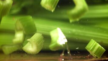 stukken van gehakt selderij vallen Aan de tafel. gefilmd Aan een hoge snelheid camera Bij 1000 fps. hoog kwaliteit full HD beeldmateriaal video