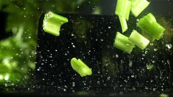 The knife cuts through the fresh sprinkled celery. Filmed on a high-speed camera at 1000 fps. High quality FullHD footage video