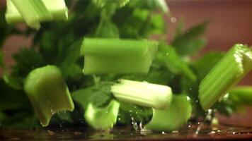 Pieces of chopped celery fall on the table. Filmed on a high-speed camera at 1000 fps. High quality FullHD footage video