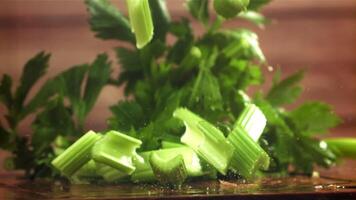 Pieces of chopped celery fall on the table. Filmed on a high-speed camera at 1000 fps. High quality FullHD footage video