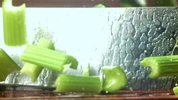 The knife cuts through the fresh sprinkled celery. Filmed on a high-speed camera at 1000 fps. High quality FullHD footage video