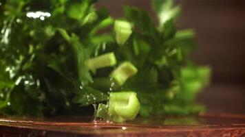 Pieces of chopped celery fall on the table. Filmed on a high-speed camera at 1000 fps. High quality FullHD footage video