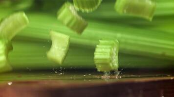 stukken van gehakt selderij vallen Aan de tafel. gefilmd Aan een hoge snelheid camera Bij 1000 fps. hoog kwaliteit full HD beeldmateriaal video