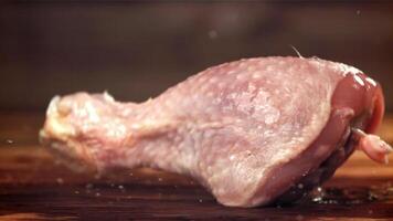 Chicken legs fall on a wooden cutting board. Filmed on a high-speed camera at 1000 fps. High quality FullHD footage video