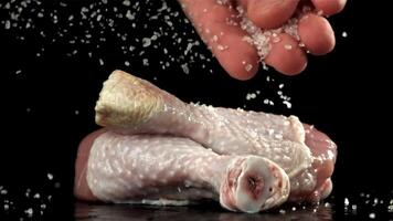 Sprinkle salt on the chicken legs. Filmed on a high-speed camera at 1000 fps. High quality FullHD footage video