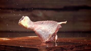 kip poten vallen Aan een houten snijdend bord. gefilmd Aan een hoge snelheid camera Bij 1000 fps. hoog kwaliteit full HD beeldmateriaal video