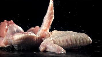 Chicken wings falling on a black background. Filmed on a high-speed camera at 1000 fps. High quality FullHD footage video