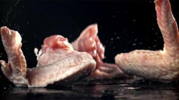 Chicken wings falling on a black background. Filmed on a high-speed camera at 1000 fps. High quality FullHD footage video