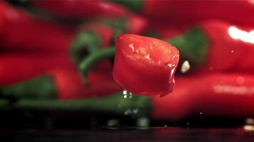 Sliced chunks of chili pepper falling on a black background. Filmed on a high-speed camera at 1000 fps. High quality FullHD footage video