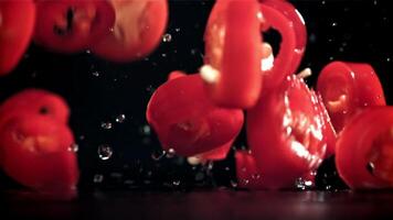 Sliced chunks of chili pepper falling on a black background. Filmed on a high-speed camera at 1000 fps. High quality FullHD footage video