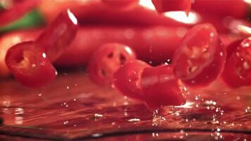 Sliced chili pepper pieces fall on a cutting board. Filmed on a high-speed camera at 1000 fps. High quality FullHD footage video