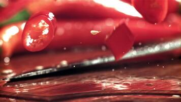 Sliced chili pepper pieces fall on a cutting board. Filmed on a high-speed camera at 1000 fps. High quality FullHD footage video