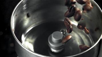 The coffee beans fall into the working grinder. Filmed on a high-speed camera at 1000 fps. High quality FullHD footage video