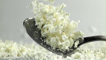 A spoonful of fresh cottage cheese falls on the table. Filmed on a high-speed camera at 1000 fps. High quality FullHD footage video