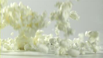 Fresh cottage cheese falling on white background. Filmed on a high-speed camera at 1000 fps. High quality FullHD footage video