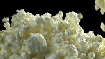 Fresh cottage cheese falling on black background. Filmed on a high-speed camera at 1000 fps. High quality FullHD footage video