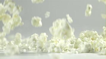 Fresh cottage cheese falling on white background. Filmed on a high-speed camera at 1000 fps. High quality FullHD footage video