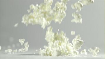 Fresh cottage cheese falling on white background. Filmed on a high-speed camera at 1000 fps. High quality FullHD footage video