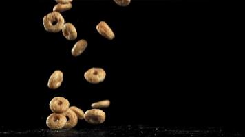 Corn flakes falling on black background. Filmed on a high-speed camera at 1000 fps. High quality FullHD footage video