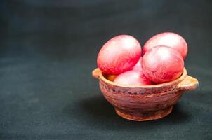 Colorful eggs in clay bowl photo