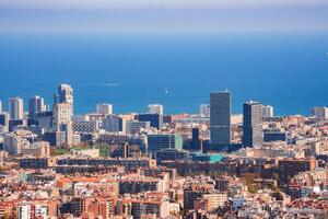 Daytime Panoramic View of Barcelona's Vast Urban Landscape and the Sea photo