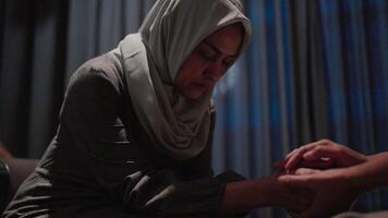 Close-up of two young female friends holding hands in support of their friend's video