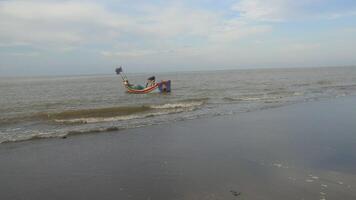 Gandapura, Aceh - December 31, 2023 - Fishermen push fishing boats into the sea near beach video