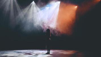 ein verzaubert Mädchen steht im Rauch und schön Beleuchtung auf das Bühne im das Theater und sieht aus mit Bewunderung beim das schön Licht. Erstaunen. Bewunderung. Magie. video