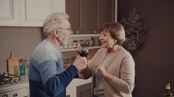 tandis que toutes les personnes est dormant, une content personnes âgées couple est ayant amusement tintement des lunettes et en buvant du vin. le secret de l'amour. anniversaire fête. réel sentiments. video