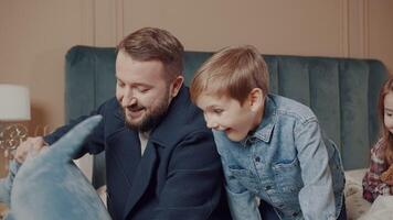 papa donne le sien fils une peluche requin jouet comme une cadeau. le joie de une fils. papa câlins le sien fils. content famille. video