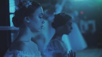 Two ballerinas are warming up and rehearsing movements backstage on stage. Preparation for the performance video