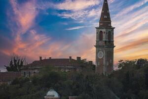 Serene Venetian Church with Clock Tower Overlooking Water at Dusk photo