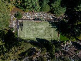 A birds eye view of a tennis court surrounded byforest. photo