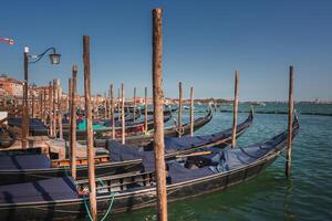 Tranquil Venice Gondolas Docked in Serene Water with Traditional Architecture in the Background photo