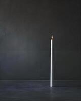 AI generated a white candle with a lit candle on top of it photo