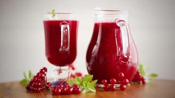 freshly squeezed thick natural juice with pulp from ripe red viburnum in a decanter on a wooden table video