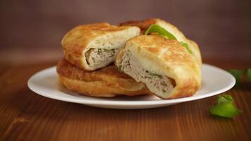 fried pies with meat in a plate on a wooden table video